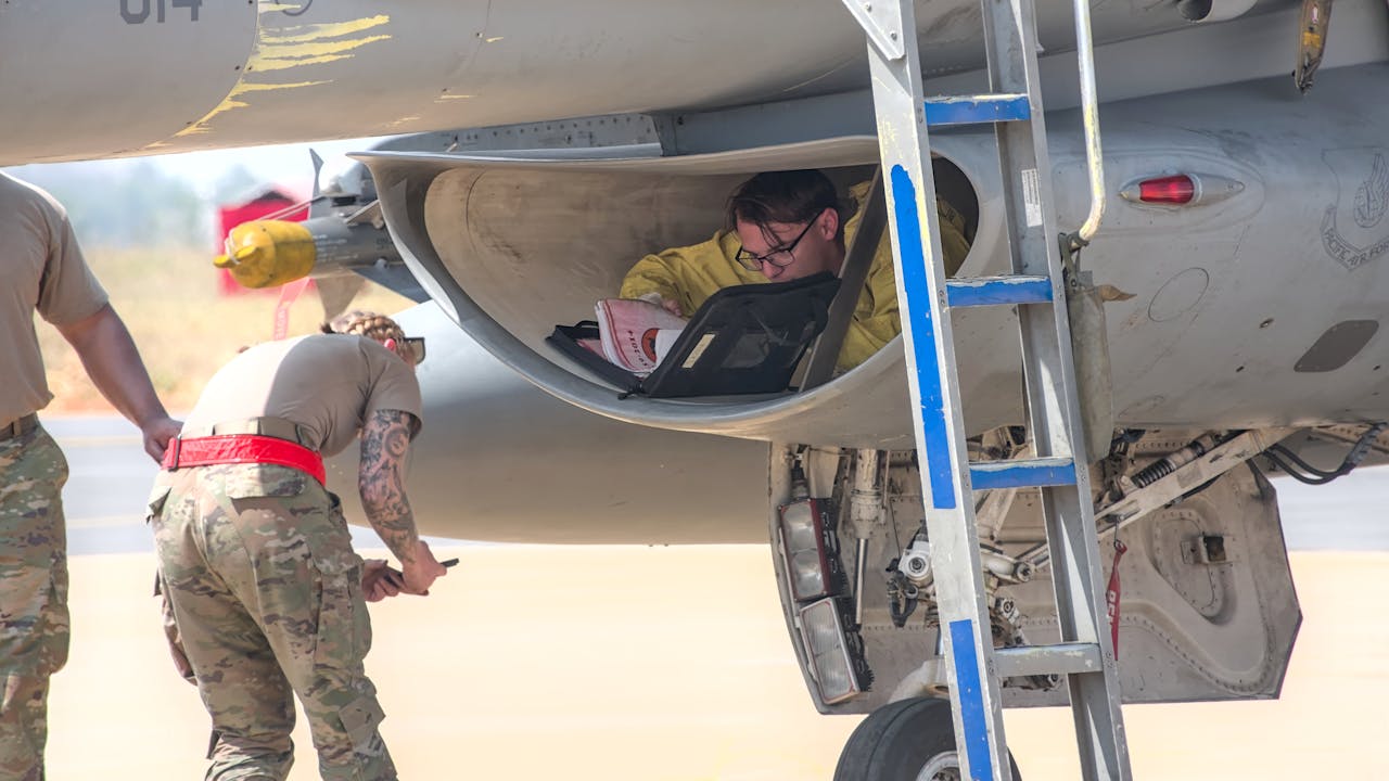 Technicians working on a military aircraft at Aero India 2025 airshow in Bengaluru.