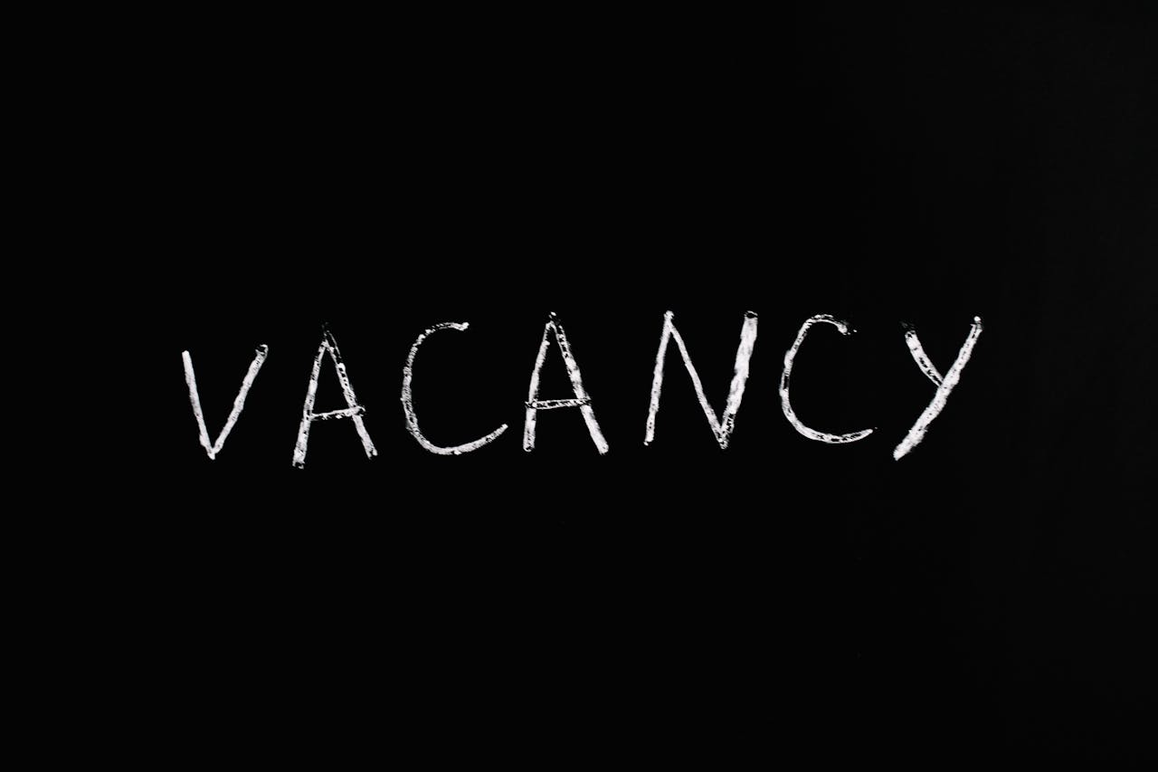 Handwritten chalk text displaying 'vacancy' on a black background.